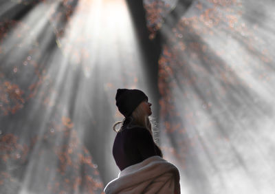 Low angle view of woman standing against blurred background