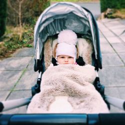 Portrait of cute baby in carriage on street