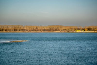 Scenic view of calm lake against blue sky