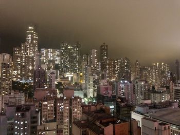 Illuminated buildings in city against sky at night