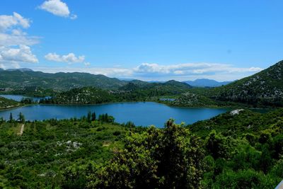 Scenic view of lake and mountains against blue sky