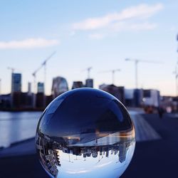 Close-up of crystal ball against buildings in city