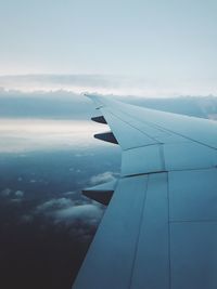 Close-up of airplane flying over sea against sky