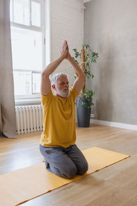 Mature man doing yoga at home