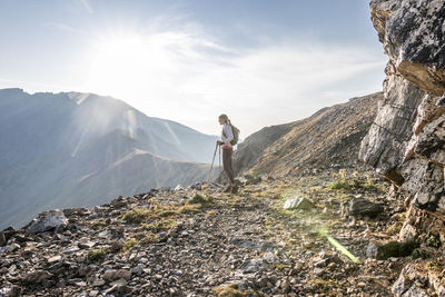 A young woman trail runner takes a break high up on arapaho pass