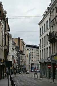 People walking on road along buildings