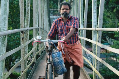 Man with a bicycle in suspension bridge