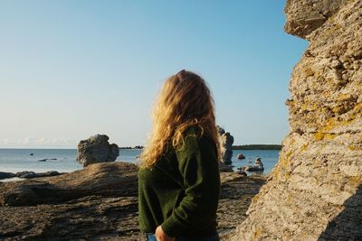 Side view of woman looking at sea against sky