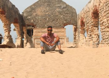 Portrait of young man sitting on rock