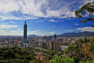 View of cityscape against cloudy sky