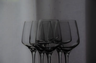 Close-up of empty glass on table against wall