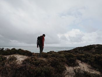 Man standing in sea against sky