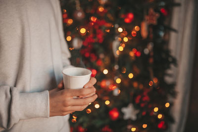 Portrait of candid authentic smiling handsome boy teenager using mobile phone at xmas home interior