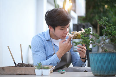 Man holding food while sitting on table