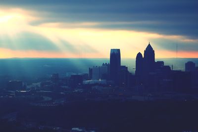 View of cityscape against cloudy sky during sunset