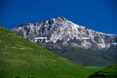 Scenic view of mountains against clear blue sky