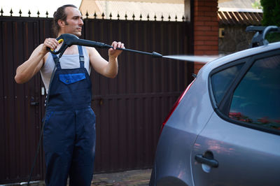 Side view of man holding car