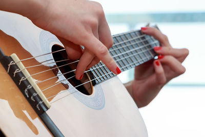 Cropped hand of woman playing guitar