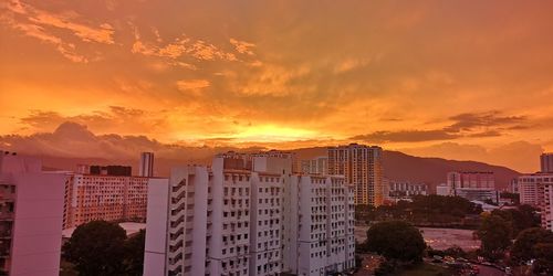 Buildings against dramatic sky during sunset