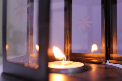 Close-up of illuminated tea light candles in building