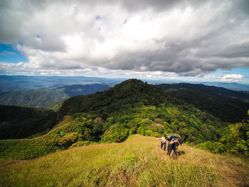 People on mountain against sky