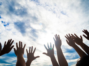 Low angle view of people hands gesturing against sky