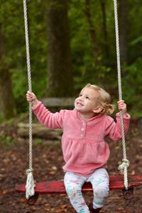 Portrait of a smiling girl on swing at playground