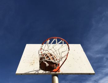 Low angle view of basketball hoop against blue sky