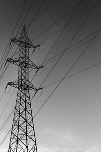 Low angle view of silhouette electricity pylon against sky