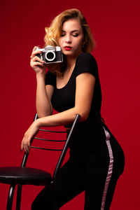 Portrait of a beautiful young woman against red background