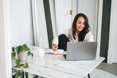 Young woman using laptop at home