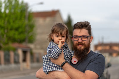 Portrait of father carrying cute daughter