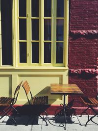 Table and chairs at sidewalk cafe against building