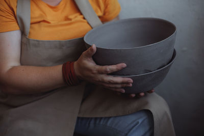 Middle-aged woman holding plates of clay