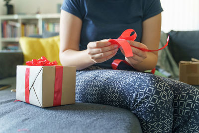 Midsection of man holding red while sitting in box