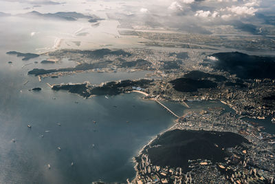 Aerial view of sea and cityscape against sky