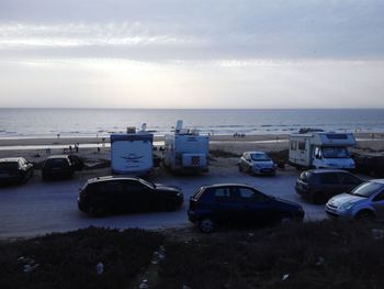 Cars on beach against sky