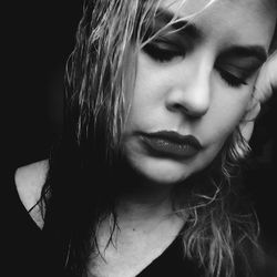 Close-up of woman against black background