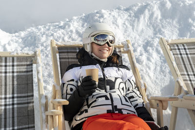 Portrait of young woman standing on snow