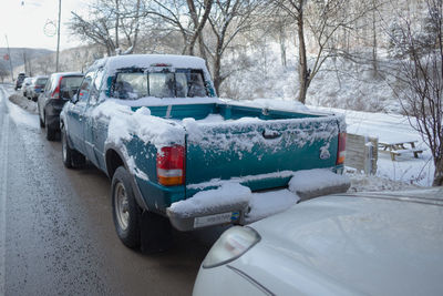 Snow covered car on street in winter