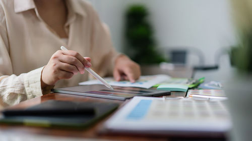 Midsection of businessman working on table