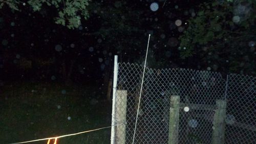 View of soccer field seen through wet fence