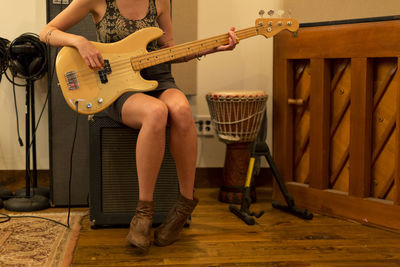 Young female musician playing a bass guitar