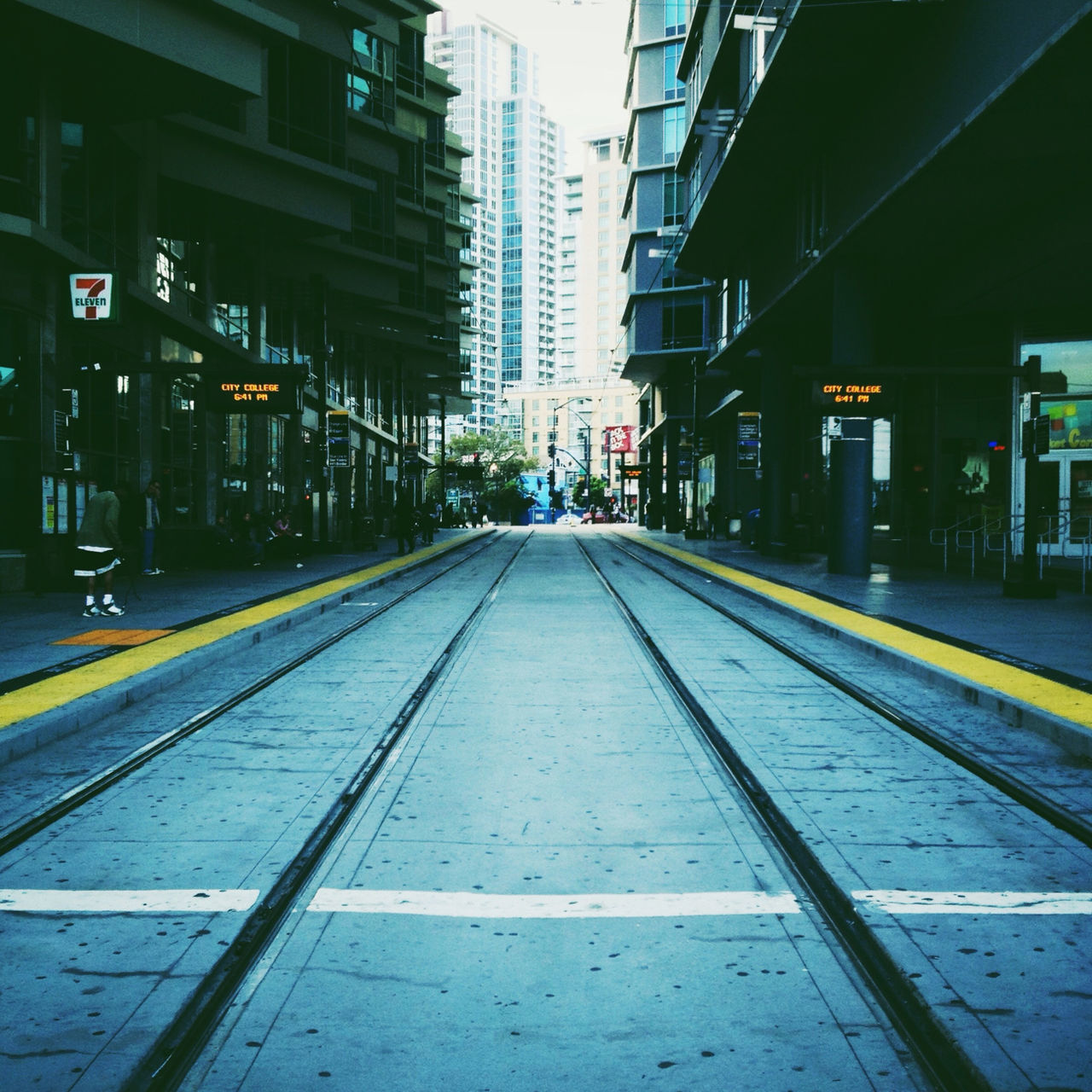 architecture, building exterior, built structure, railroad track, city, transportation, the way forward, diminishing perspective, rail transportation, illuminated, public transportation, railroad station platform, vanishing point, building, city life, railroad station, surface level, no people, outdoors, empty