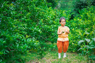 Thoughtful girl standing amidst plants