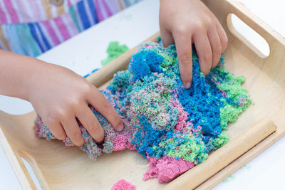 High angle view of woman hand holding multi colored table