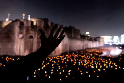 Silhouette person against illuminated buildings in city at night