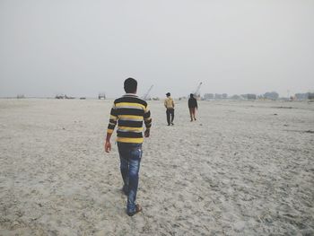 Rear view of men walking on road