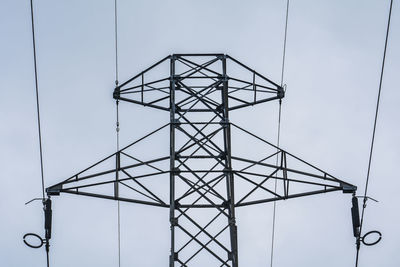 Low angle view of electricity pylon against sky