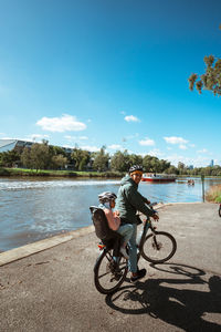 Man riding bicycle on beach against sky